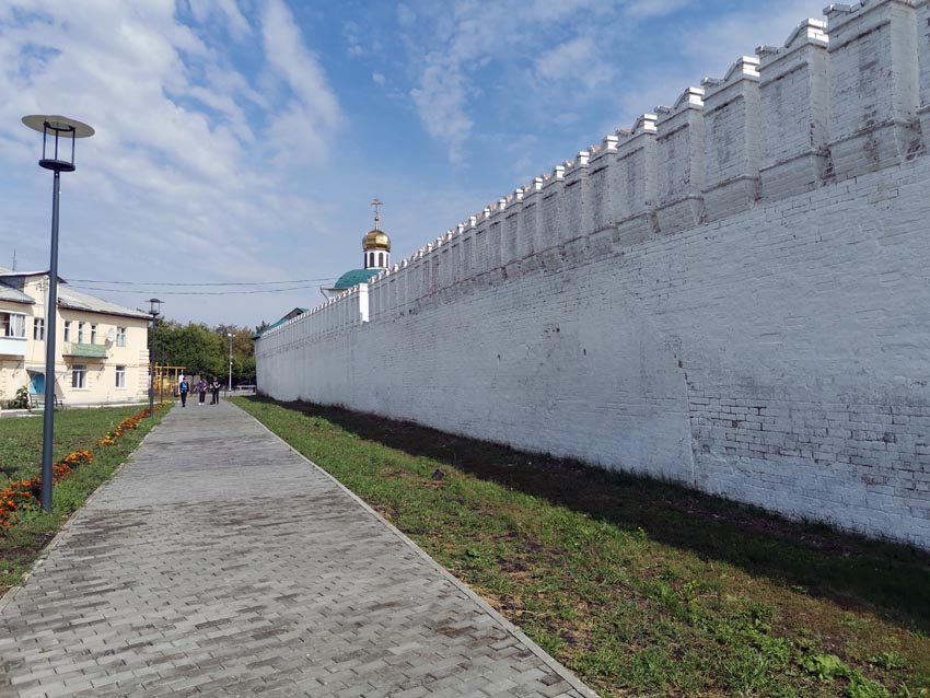 Дорожка вдоль крепостной стены Далматовского монастыря. За стеной виднеется купол надвратного храма Иоанна Богослова